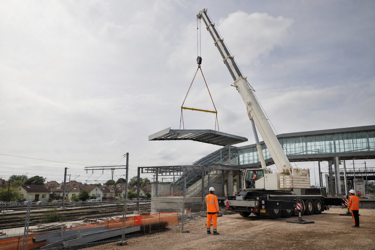 Mise en situation d’un grue mobile automotrice avec une équipe de levage pour levage sur emprise du pôle gare, dans un environnement inspiré de Chelles