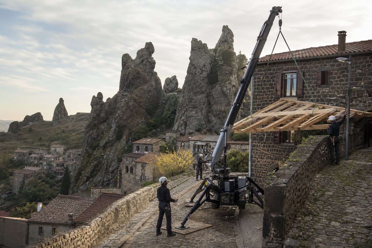 Mise en situation d’un mini-grue araignée avec une équipe de levage pour restauration d'une toiture, pied du rocher corneille, dans un environnement inspiré de Le Puy-en-Velay