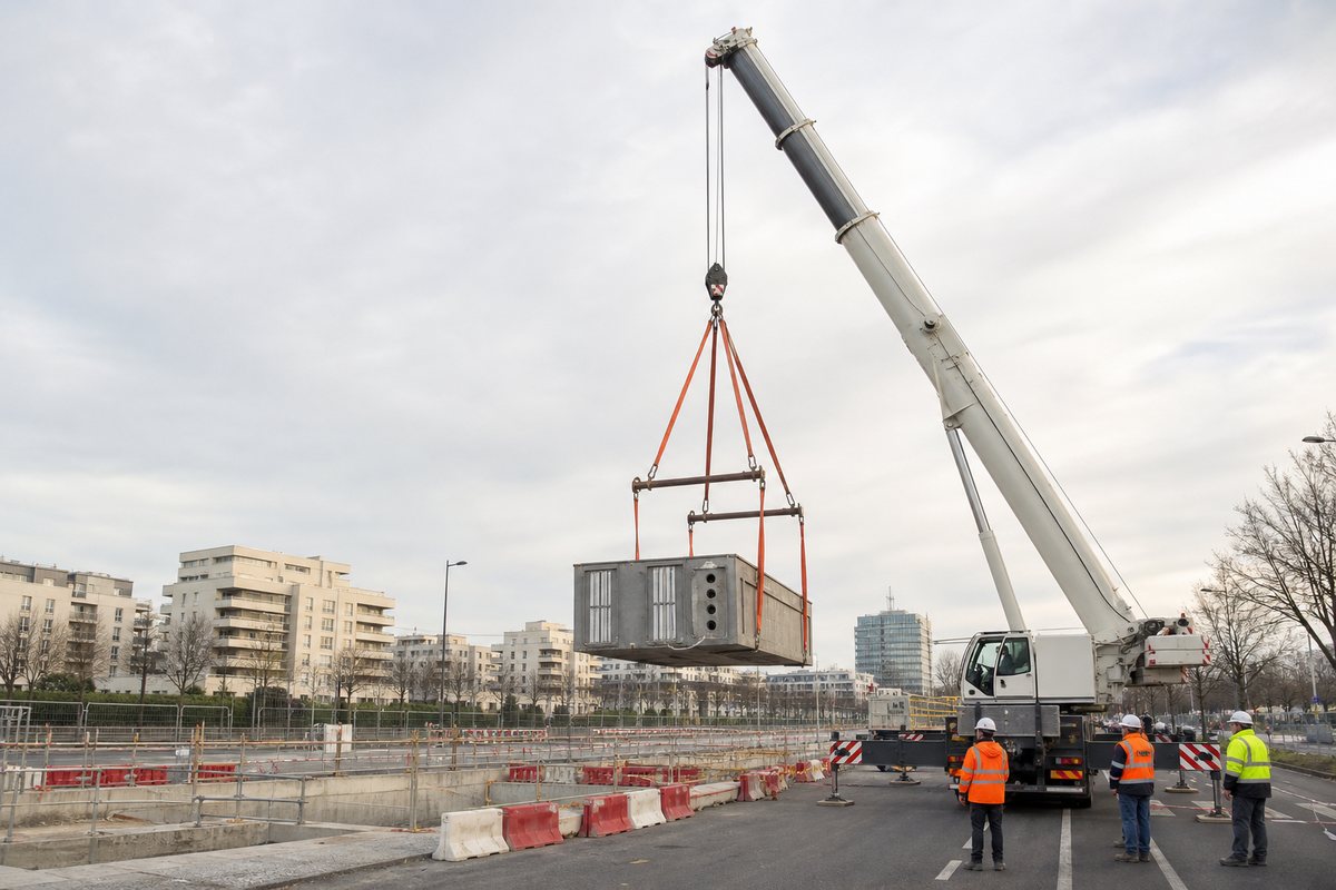 Mise en situation d’un grue mobile automotrice avec une équipe de levage pour manutention sur emprise de la ligne 15 sud, dans un environnement inspiré de Maisons-Alfort